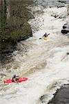 High angle view of kayakers paddling River Dee white water rapids, Llangollen, North Wales