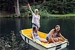 Three adult female friends on rowing boat in lake, Sattelbergalm, Tirol, Austria