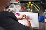 Cropped view of man slicing red onion