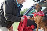 Man cleaning dog's paws with towel