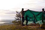 Hikers setting up tent on hilltop, Keimiotunturi, Lapland, Finland