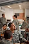 Group of soldiers relax and chat together in the army canteen.