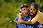 Portrait of elderly man in a wheelchair with his daughter.