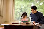 Father helping his daughter with her homework.