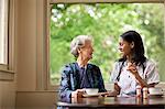 Female nurse explaining how to take medication to a senior patient.