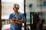 Smiling mature man sending a text message on a cell phone.