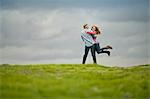 Happy middle aged man spinning his teenage daughter around.