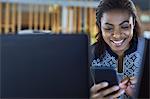 Smiling businesswoman texting with cell phone