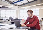 Businessman working at laptop in office