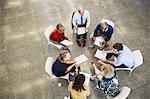 Business people discussing paperwork in meeting circle