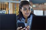 Businesswoman texting at computer in office