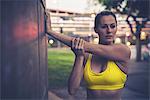 Young woman stretching, leaning against wall