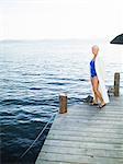 A senior woman with swimming clothes on a jetty.