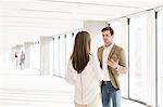 Young businessman discussing with female colleague in new office