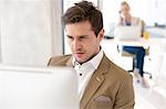 Young businessman using computer in new office