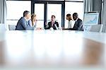 Multi-ethnic business people having discussion at table in board room