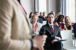 Businessman looking at public speaker during seminar