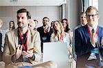 Confident business people applauding during seminar