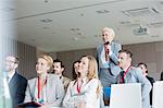 Smiling businesswoman asking questions during seminar