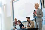 Businesswoman giving presentation in seminar hall