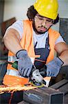 Young manual worker grinding metal in industry