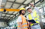 Supervisor showing something to manual worker in metal industry