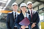 Portrait of mature businesswoman with male colleagues in metal industry