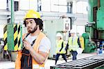 Young manual worker operating machinery in metal industry