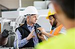 Male inspector having discussion with worker in metal industry