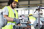 Young manual worker operating machinery in metal industry