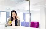 Beautiful young businesswoman using mobile phone in office
