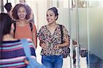 Smiling female college students walking in corridor