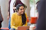 Smiling female college students with coffee and laptop