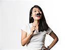 Chinese woman having fun with a fake mustache