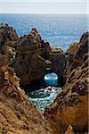 Natural Arch in Rocks and Ocean at Lagos. Algarve Coast, Portugal