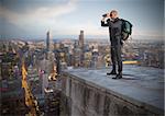Businessman with backpack and binoculars watching from above the city