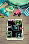 Back to school concept with digital tablet and colorful stationery on wooden surface.