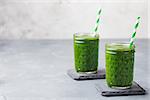 Spinach smoothie Healthy drink in glass jar on grey stone background Copy space