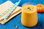 Pumpkin smoothie with pumpkin pie spices on blue wooden background