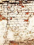 Grunge background with texture of old brick wall painted cracked paint of white color