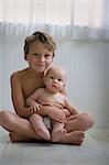 Portrait of a young boy holding his baby brother.