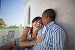 Mid-adult couple hugging outside.