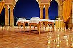 Massage tables set up on a candlelit patio at a resort.