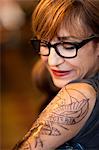 Portrait of woman with a fresh tattoo on her arm.