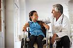 Young girl in a wheelchair talking to her doctor.