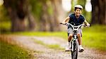 Boy riding his bike on a footpath.