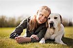 Smiling teenage girl with her Labrador dog.