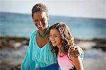 Grandmother and granddaughter walking on the beach.