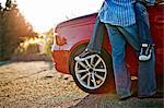 Low section view of couple being affectionate by their car.