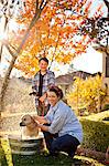 Portrait of a mid-adult woman and her son giving their dog a bath in the backyard.